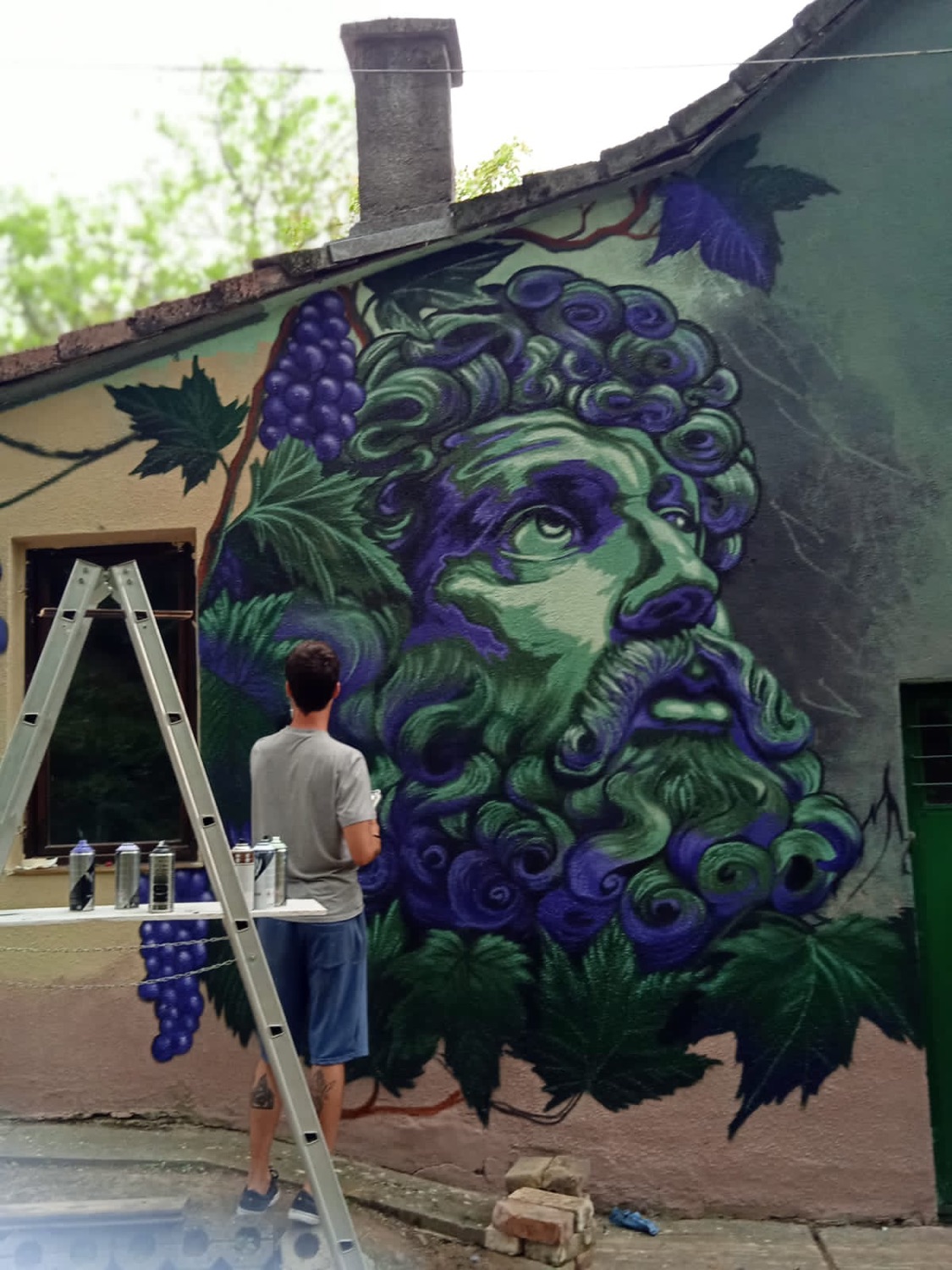 Green portrait mural painted outdoors